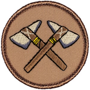 May include: A brown embroidered patch with two crossed tomahawks. The tomahawks are brown with yellow accents and have a white and blue blade.