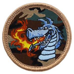 May include: A round embroidered patch with a blue dragon breathing fire. The patch is on a camouflage background with a tan border.