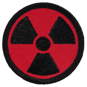 May include: A round, red patch with a black radiation symbol in the center. The symbol is composed of three black blades radiating from a central black circle. The patch has a black border.