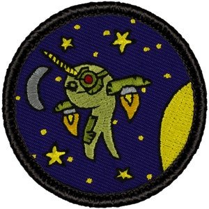 May include: A round, embroidered patch with a dark blue background. A green, cartoon-like creature with a horn and rocket boosters flies through a starry night sky. The creature has a red eye and a yellow moon is in the background.