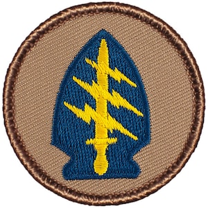 May include: A brown embroidered patch with a blue and yellow spearhead design. The spearhead has a yellow lightning bolt design inside.