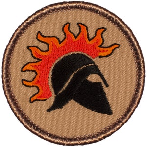 May include: A brown embroidered patch with a black Spartan helmet with a red and orange flame design on top.