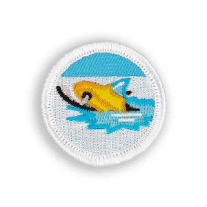 May include: Embroidered patch featuring a swimmer in yellow and black, with blue water and a light blue sky. The patch is circular with a white border, suitable for sewing onto clothing or bags.