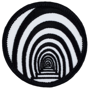 May include: Black and white embroidered patch with a circular design of concentric circles creating a hypnotic spiral effect.