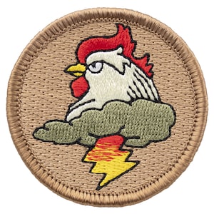 May include: Embroidered patch featuring a white rooster with a red comb and wattle, perched on a green cloud with a yellow and red lightning bolt underneath. The patch is circular and has a brown background.