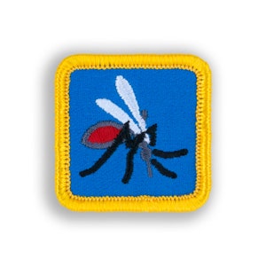 May include: A blue embroidered patch with a yellow border, featuring a cartoon mosquito with black legs, a red head, and white wings.