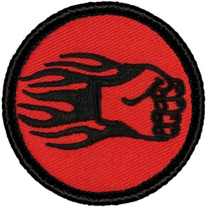 May include: A red and black embroidered patch with a black fist in flames. The fist is clenched and the flames are stylized.