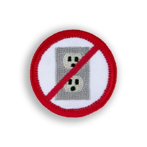 May include: A red circle with a white background and a red diagonal line through a gray electrical outlet. The text "No Outlet" is written in black letters.