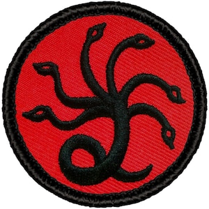 May include: A black embroidered patch with a red background. The patch features a stylized image of a five-headed serpent with a coiled tail.