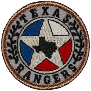 May include: A gray embroidered patch with a brown border. The patch features a white star with a black outline, with the state of Texas inside the star. The star is surrounded by a blue, white, and red circle. The words "TEXAS RANGERS" are written around the star in a black font.