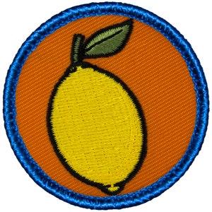 May include: A yellow lemon with a green leaf on a bright orange background surrounded by a blue border.