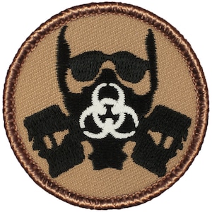 May include: A round, tan embroidered patch with a black gas mask and biohazard symbol. The gas mask has black goggles and a white biohazard symbol.