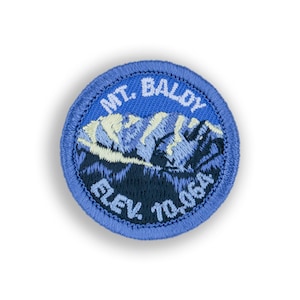 May include: A blue embroidered patch with a mountain range design and the text "MT. BALDY ELEV. 7006A".
