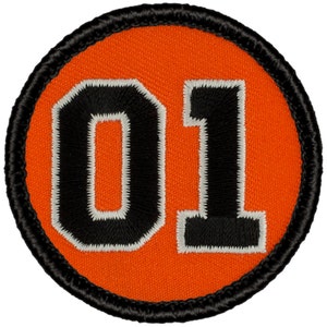 May include: A round orange patch with a black border and the number "01" in black with a white outline.