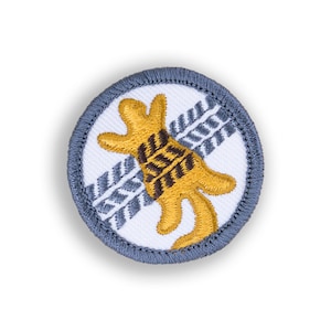 May include: A blue and white embroidered patch with a yellow animal with brown markings, surrounded by a gray border.