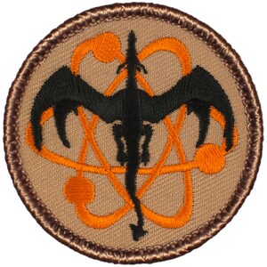 May include: A brown embroidered patch with a black dragon silhouette inside an orange atomic symbol.