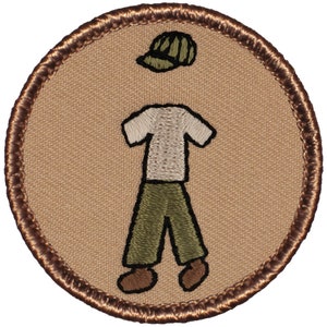 May include: A brown embroidered patch with a cartoon figure wearing a green cap, a white t-shirt, green pants, and brown shoes.