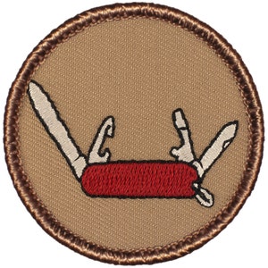May include: A brown embroidered patch with a red and white multi-tool pocket knife.