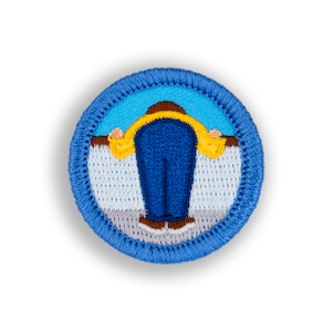 May include: A blue and yellow embroidered patch with a person wearing a yellow jacket and blue pants standing in front of a white picket fence.