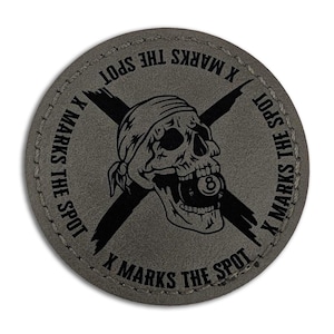 May include: A round, gray patch with the phrase "X MARKS THE SPOT" encircling a skull wearing a bandana and holding an 8-ball in its mouth. Black crossed swords are behind the skull.