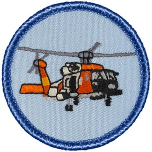 May include: A round, blue-bordered patch with an embroidered image of an orange and black Coast Guard helicopter.