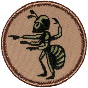 May include: A brown and black embroidered patch with a cartoon ant with multiple arms and legs. The ant is pointing with its arms.