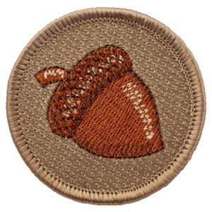 May include: A brown embroidered acorn patch with a tan background and a stitched border.