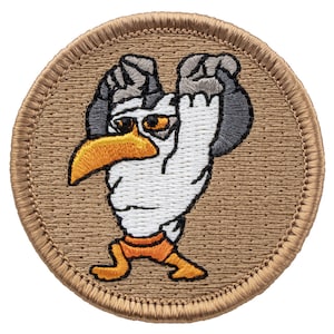 May include: A round, tan-colored patch with a white seagull wearing orange shorts lifting a gray dumbbell. The seagull has a yellow beak and black eyes.