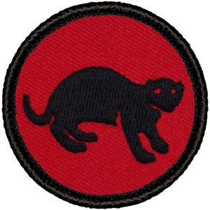 May include: A red embroidered patch with a black silhouette of a weasel. The patch is circular and has a black border.