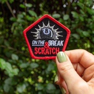 May include: A red, black, and white embroidered patch with a black 8-ball and the text "On the & Break Scratch".