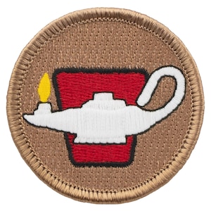 May include: A brown embroidered patch with a white oil lamp with a yellow flame and a red base. The patch is circular and has a brown stitched border.