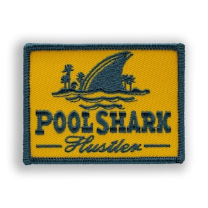 May include: Embroidered patch with a yellow background and a navy blue border. The patch features a shark fin, palm trees, and the words "POOL SHARK - Hustler" in navy blue.