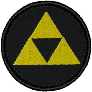 May include: A black and yellow embroidered patch with the Triforce symbol from the Legend of Zelda video game series.