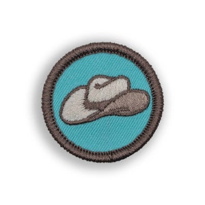 May include: A brown embroidered patch with a white cowboy hat on a turquoise background.