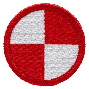 May include: A circular patch with a red border and a design of four quadrants. Two quadrants are white, and two are red. The patch is likely an emblem or insignia, possibly for a uniform or garment.