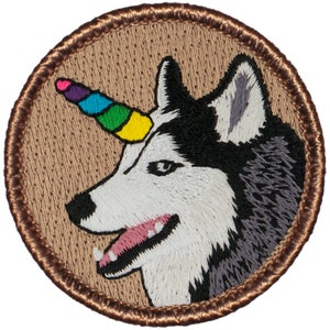 May include: Embroidered patch featuring a white and black husky with a rainbow unicorn horn. The patch is circular and has a brown border.