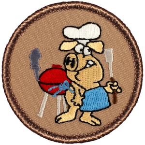 May include: Embroidered patch featuring a cartoon animal wearing a chef's hat and holding a spatula. The animal is standing next to a red grill with smoke coming out of it. The patch is brown with a brown border.