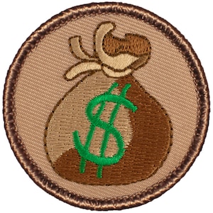 May include: A brown and tan embroidered patch with a brown money bag with a green dollar sign on it. The patch has a brown stitched border.
