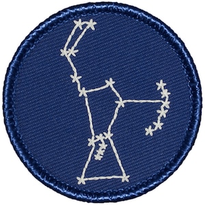 May include: A blue circular patch with a white embroidered constellation of stars. The constellation is a stylized depiction of the constellation Ursa Major, also known as the Great Bear.