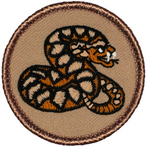 May include: A brown and black embroidered patch with a coiled snake design. The snake is brown with black stripes and has a white eye.