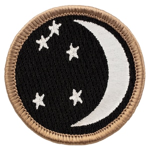 May include: A round, brown embroidered patch with a white crescent moon and five white stars on a black background.