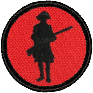 May include: A red embroidered patch with a black silhouette of a person holding a rifle. The patch is circular with a black border.