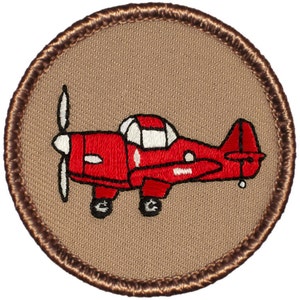 May include: A brown embroidered patch with a red airplane with white accents. The airplane has a propeller and is on a brown background.