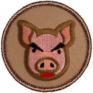 May include: A brown embroidered patch with a pink pig face. The pig has a brown snout, black eyes, and a red mouth. The pig is frowning.
