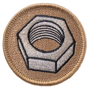 May include: A brown embroidered patch with a white and black embroidered nut shape.