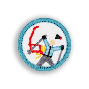 May include: A blue and white embroidered patch with a skier falling down. The skier is wearing a blue and white shirt, gray pants, and black gloves. The skier is holding two ski poles. The patch is circular and has a blue border.