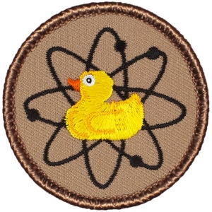 May include: A brown embroidered patch with a yellow rubber ducky inside an atomic symbol.