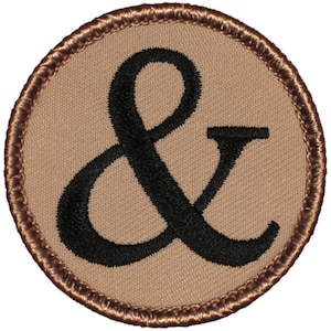 May include: A brown and black embroidered patch with an ampersand symbol in the center.