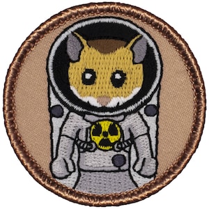 May include: A brown embroidered patch with a cartoon image of a yellow and brown mouse wearing a gray spacesuit and holding a yellow and black radioactive symbol.