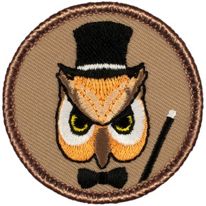 May include: Embroidered patch featuring a brown owl wearing a black top hat with a white band, a black bow tie, and holding a white and black walking stick. The owl has yellow eyes and is set against a tan background.